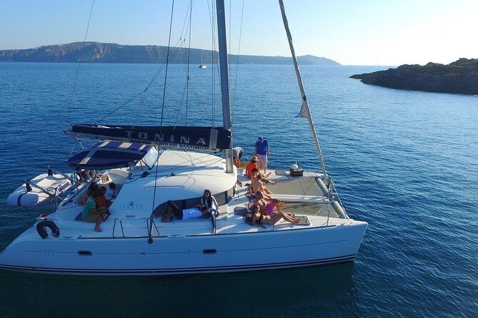 Santorini Full Day Catamaran Private Cruise incl. Meal, Drinks & Free Transport - White Beach: Quiet Contrast Next to the Famous One