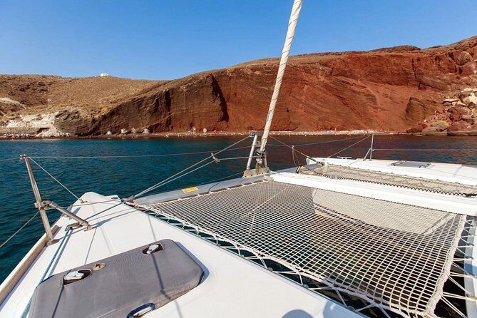 Santorini Half Day Catamaran Private Cruise incl. Meal, Drinks & Free Transport - Red Beach by boat: ferrous rocks, Akrotiri proximity, and the best angles