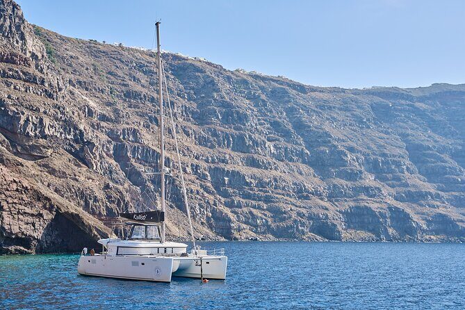 Santorini: Luxury Catamaran Cruise with Fresh Fish BBQ & Drinks - Entering Santorini by sea, not just from shore